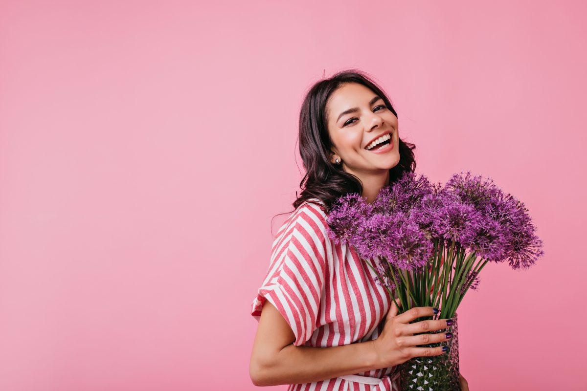 positive-brunette-with-dimples-radiates-joy-snapshot-cute-curly-lady-with-lovely-huge-purple-flowers-1200x800.jpg